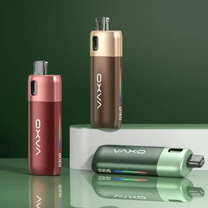 Three oxva vape devices on a reflective surface with a green background